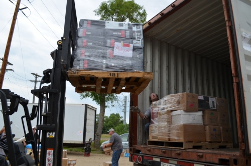 Loading the shipping container with donated computers and educational materials, for transport to Ghana.