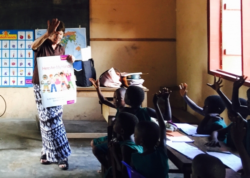 Joan teaching students, using newly donated educational materials.
